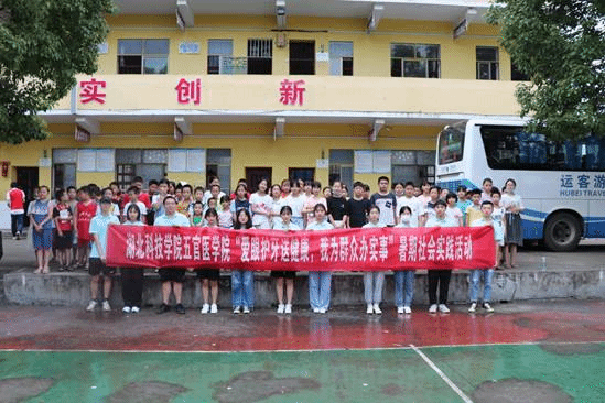 7月17日,实践活动团队全体队员与厦铺小学的小学生们合照